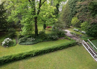 professionelle Gartenpflege eines Hotelgartens: Rasenfläche, Hecken, Stauden- und Rosenrabatten, repräsentativer Eingangsbereich