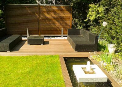 Loungebereich Wasserspiel in einem Garten mit Holzterrasse
